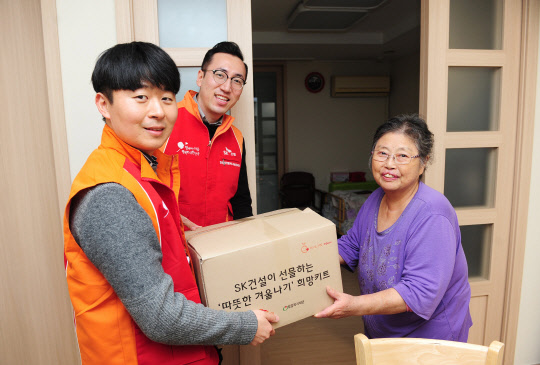 SK건설 구성원들이 후원가정에 방문해 방한키트를 전달하는 모습. <SK건설 제공>